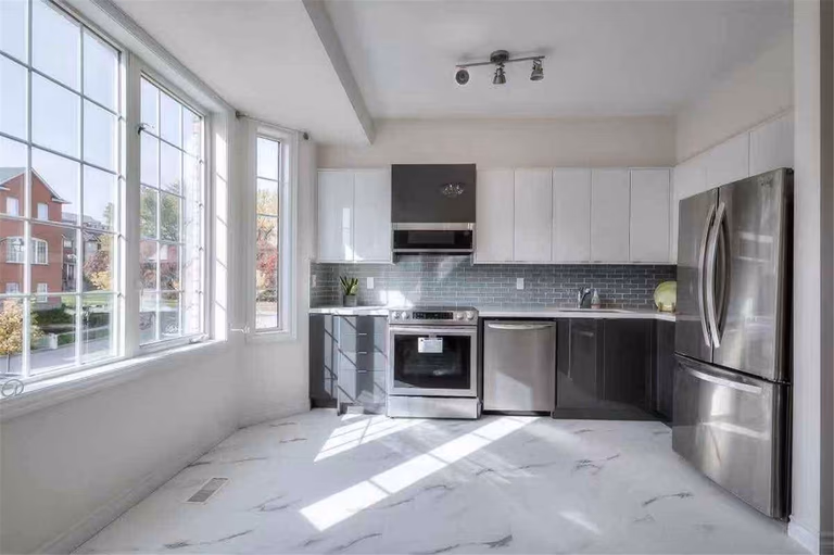 This Thornhill interior renovation showcases a spacious living room upgrade featuring new vinyl flooring, fresh wall painting, modern pot lights, and a refreshed fireplace feature wall. Large windows and sliding patio doors enhance natural light and openness, creating a bright and welcoming environment. Completed by a professional Toronto renovation team, this renovation highlights quality craftsmanship and modern interior design for comfortable family living.