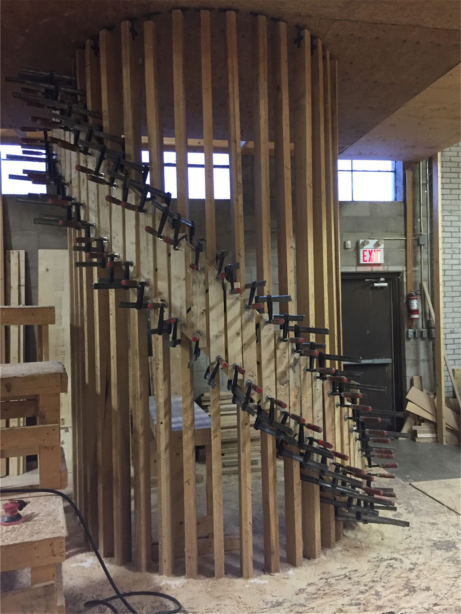 This image shows the construction phase of a custom curved staircase during a Toronto stair renovation project. Vertical wood framing and precision clamping techniques are used to shape the staircase structure, ensuring accurate curvature and strong structural support. The carefully aligned framing demonstrates skilled craftsmanship required for complex staircase designs. As a professional Toronto Renovation Company, Reno Compass Inc. specializes in custom staircase construction, delivering durable and architecturally striking stair solutions for homes and commercial spaces across Toronto and the GTA.