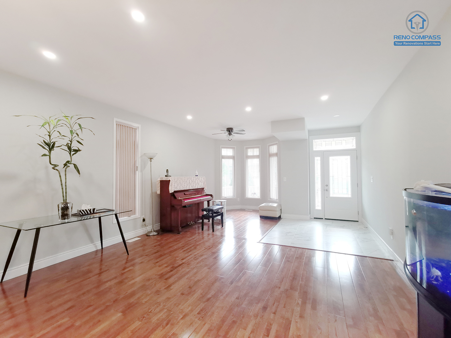 This Markham interior renovation showcases a bright, open-concept living and dining area designed to enhance natural light, flow, and everyday comfort. Continuous hardwood flooring visually extends the space while maintaining warmth and durability for long-term use. Recessed ceiling lights and a neutral wall palette create a calm, balanced backdrop that allows flexible furniture placement and multiple functional zones. Large windows and a full-height entry door bring in abundant daylight, improving the sense of openness and connection to the exterior. Completed by Reno Compass, this interior renovation reflects a clean, adaptable layout tailored for modern Markham homes seeking clarity, proportion, and livable design.