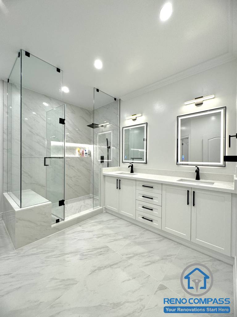 This modern Vaughan bathroom renovation features a clean and elegant layout with a double vanity, quartz countertop, and sleek black fixtures. A frameless glass shower with large-format marble-look tiles creates a spacious and luxurious feel, while the freestanding bathtub adds a spa-like touch. Completed by a professional Toronto Renovation Company, this bathroom design focuses on functionality, durability, and timeless modern aesthetics.