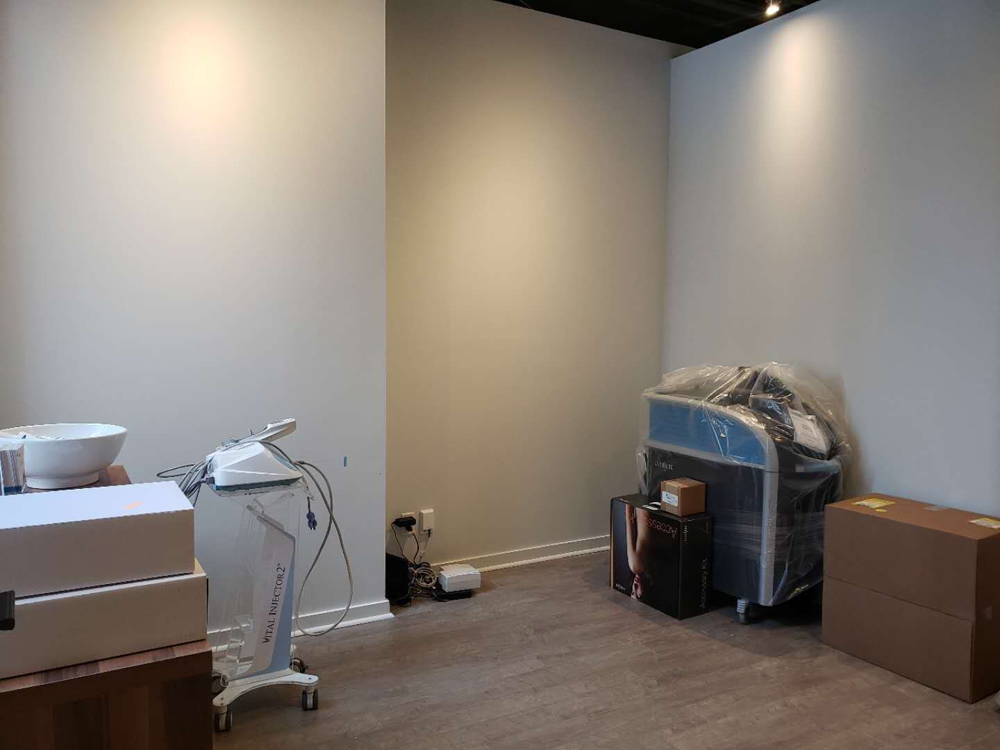 This image captures a treatment room in preparation phase as part of a beauty and massage spa commercial renovation completed by a professional Toronto renovation company. The space features freshly finished walls, durable wood-look flooring, and overhead track lighting, providing a clean and flexible foundation for spa treatment equipment installation. The open layout allows for efficient placement of massage beds, skincare machines, and storage units while maintaining a calm and uncluttered environment. This type of renovation approach is ideal for wellness clinics, medical aesthetics studios, and massage spas across Toronto and the GTA that require functional, adaptable, and professional treatment room designs.
