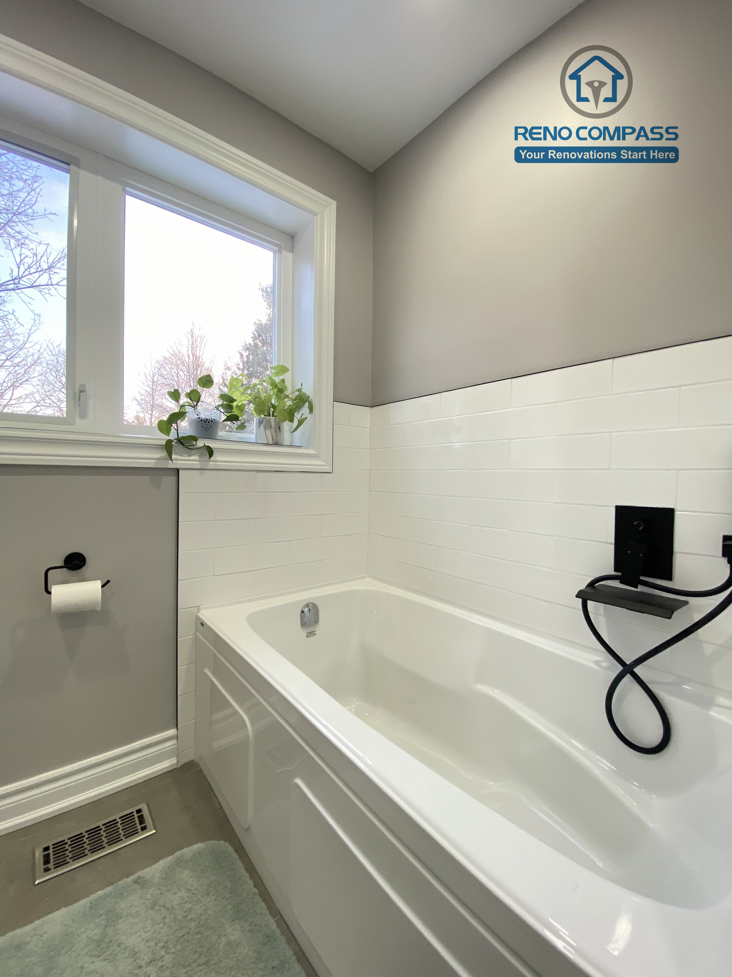 This North York bathroom renovation showcases a clean built-in bathtub paired with matte black fixtures and classic white subway tile walls. Natural light from the window enhances the soft gray palette, creating a calm and functional bathing space designed and completed by a Toronto renovation company focused on durability, comfort, and timeless design.