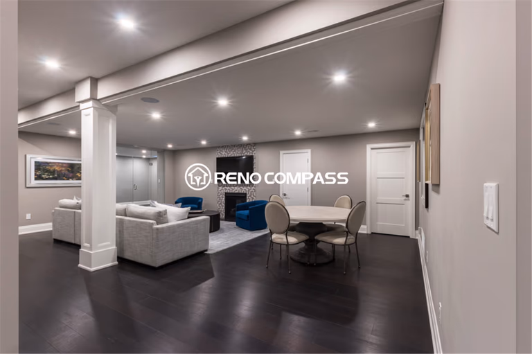 Spacious luxury basement renovation in Toronto featuring an open-concept layout with dark hardwood flooring, recessed ceiling lighting, modern lounge seating, and a stylish entertainment area. This elegant and functional basement living space was professionally designed and completed by a trusted Toronto renovation company, Reno Compass Inc.