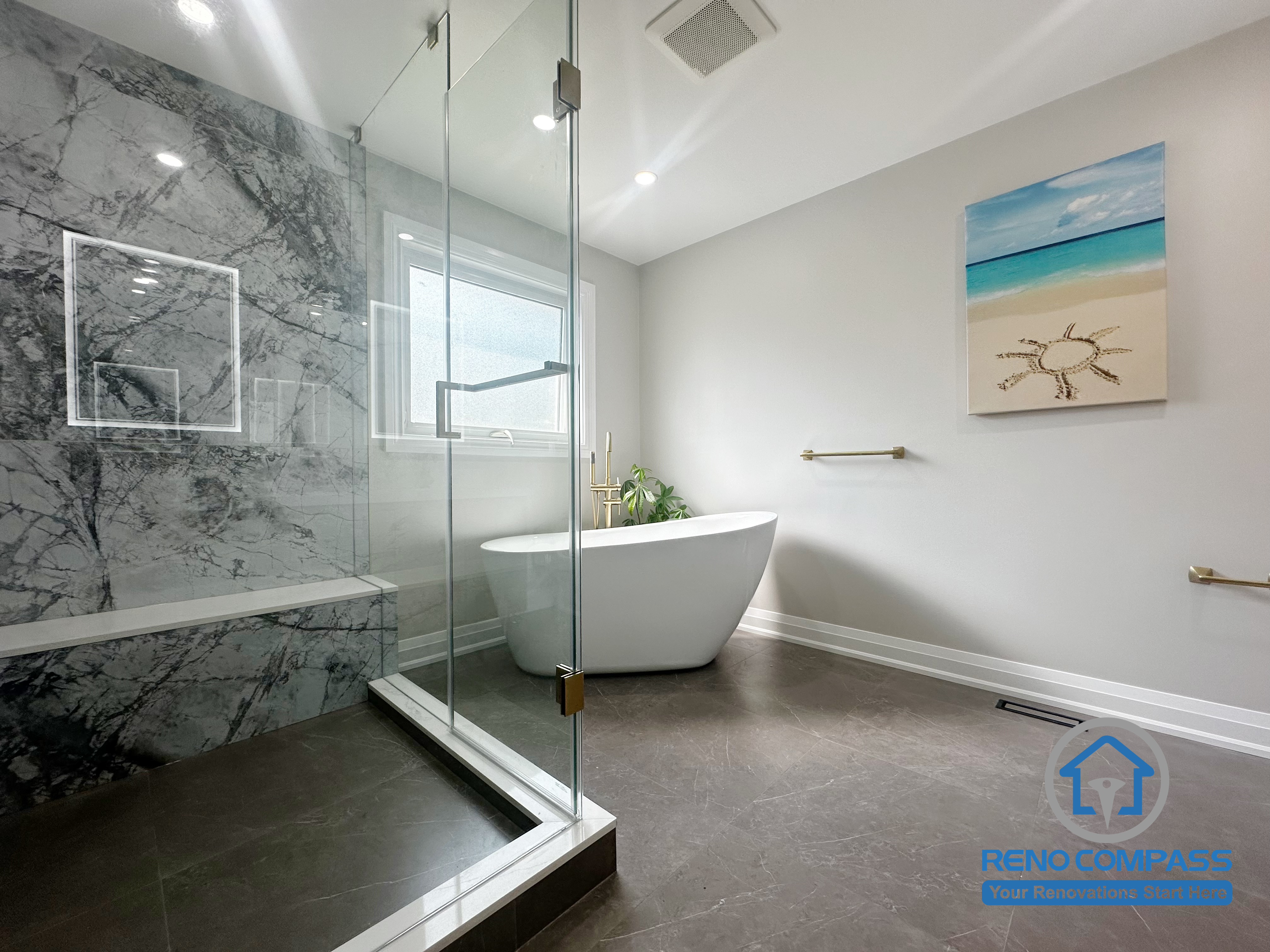 This Oakville bathroom renovation features a clean, modern layout with a frameless glass shower, large-format marble-look wall tiles, and a freestanding soaking tub positioned near natural light. The design focuses on clear proportions, practical circulation, and durable finishes suitable for long-term daily use. Completed by Reno Compass, this project reflects a balanced approach to contemporary bathroom design in Oakville homes.