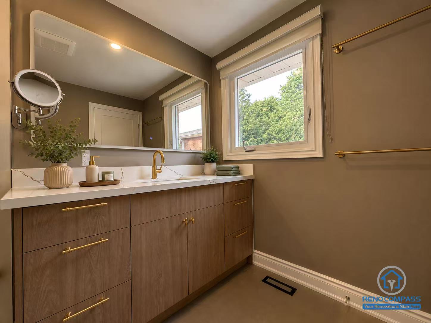 Modern bathroom renovation featuring a custom walnut vanity, white quartz countertop, brushed gold faucet and hardware, oversized wall mirror, and contemporary finishes. Designed and built by Reno Compass in the Greater Toronto Area.