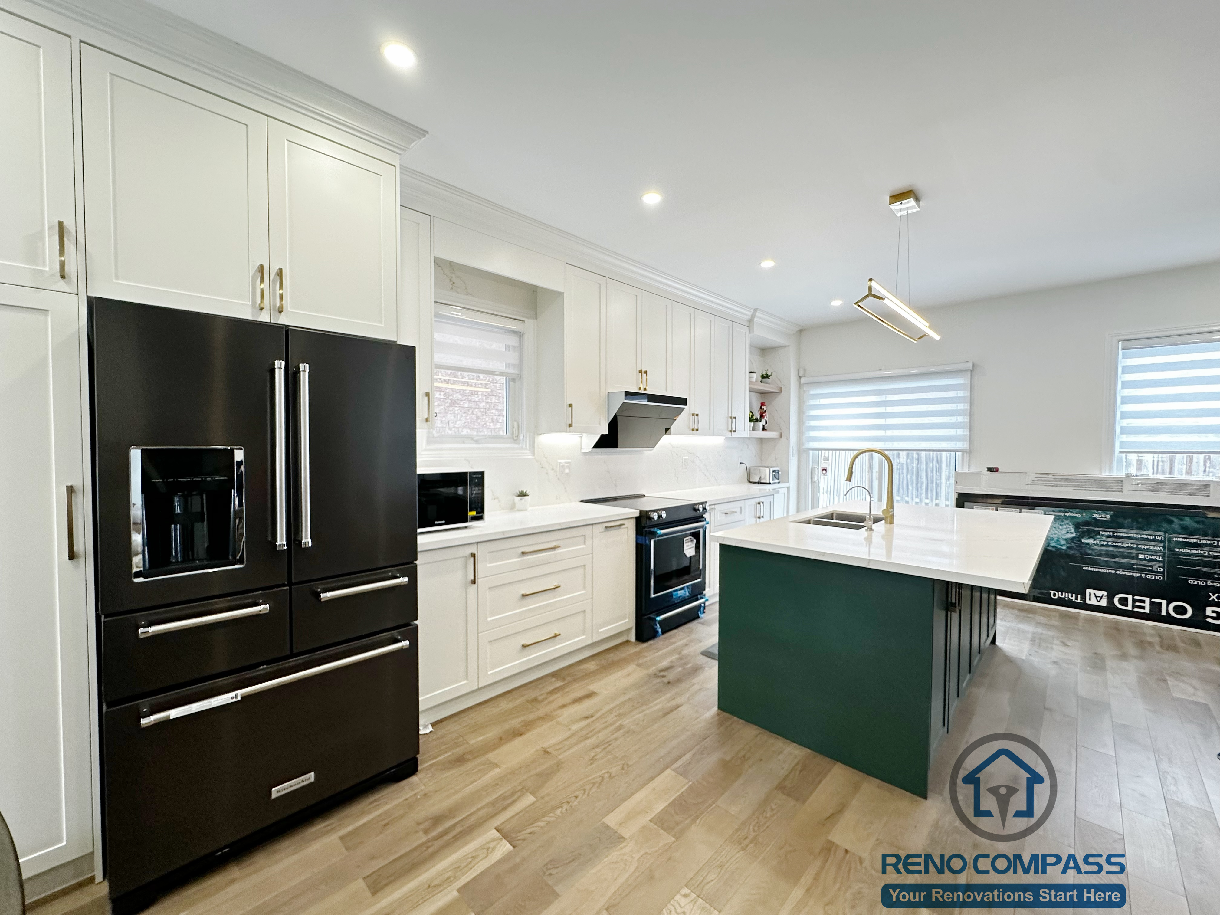 Interior renovation in Markham featuring a custom kitchen with full-height white cabinetry, a bold green island, quartz countertops, and modern pendant lighting. The design balances visual contrast with functionality, creating a bright and efficient central living space.