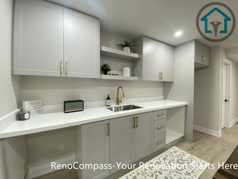 该画面展示了本次旺市地下室翻新项目中的定制橱柜与洗手台区域。Reno Compass 团队根据地下室使用需求，规划并安装整套定制橱柜系统，结合洗手台与操作台面，为地下空间提供实用的清洁与辅助功能。整体设计以浅色柜体搭配简洁线条，兼顾储物效率与视觉整洁度，使地下室在满足日常使用的同时，保持统一、现代的空间风格。