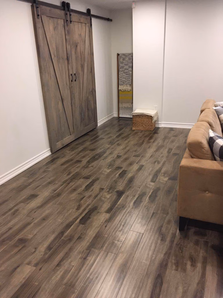 This Richmond Hill basement renovation showcases a clean and modern finished space with newly installed dark hardwood flooring, fresh neutral wall paint, upgraded ceiling lighting, and improved layout. The renovated basement room is designed to provide a comfortable and functional living or storage area, enhancing the home’s value and usability with a bright, contemporary finish.