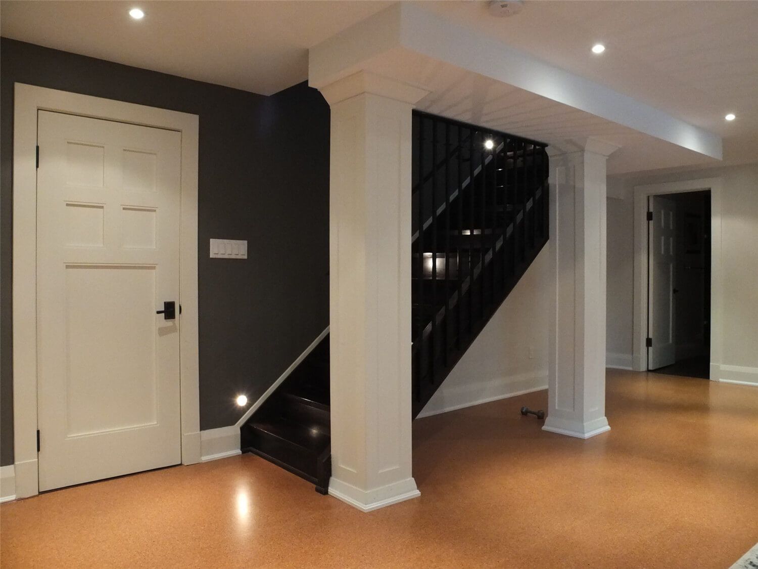 This Oakville basement renovation highlights a refined staircase area featuring custom columns, recessed pot lighting, and engineered flooring. The design enhances both structure and visual depth, creating a clean transition between basement spaces. Completed by a professional Toronto Renovation Company, the project combines detailed carpentry, modern finishes, and functional layout planning to deliver a stylish and well-lit basement interior.