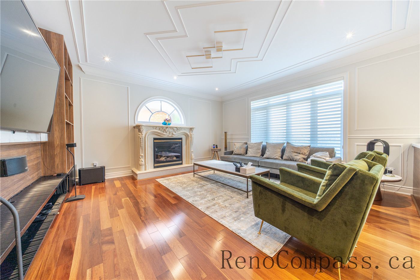 This Richmond Hill entire house interior renovation highlights an elegant open-concept dining and living area featuring rich hardwood flooring, custom ceiling detailing, and decorative columns. Large windows and a bright foyer connection enhance natural light and spatial flow throughout the home. The refined layout and timeless finishes create a warm, luxurious atmosphere, professionally completed by a leading Toronto renovation company focused on quality craftsmanship and modern functionality.