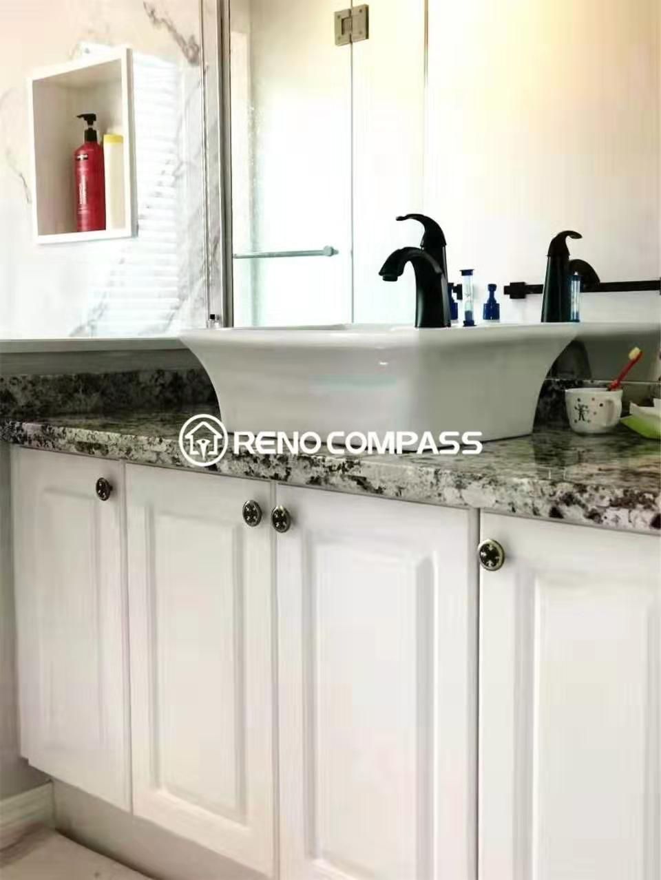 Elegant bathroom vanity installation featuring custom white cabinetry, a granite countertop, and modern matte black faucets. This Toronto renovation company project highlights clean finishes, practical storage solutions, and durable materials designed for everyday use. The coordinated vanity and mirror design enhances both functionality and visual appeal, completing a refined and contemporary bathroom space.