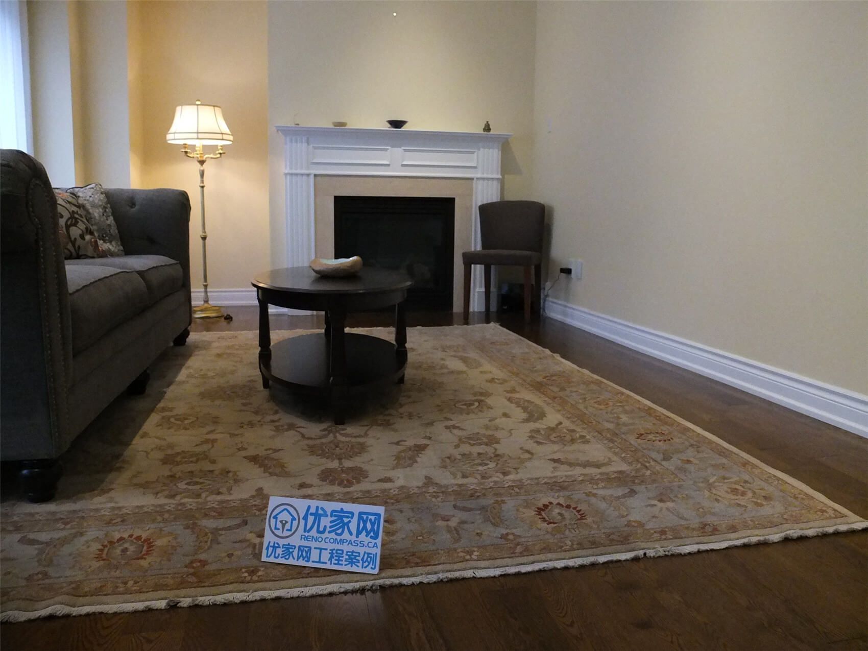 This Aurora flooring renovation showcases newly installed hardwood flooring in a cozy living room space featuring a classic fireplace and elegant seating area. The rich wood flooring enhances the warmth of the room and pairs beautifully with the neutral wall tones and traditional décor. Completed by a trusted Toronto renovation company, the flooring upgrade improves both the visual appeal and long-term durability of this comfortable living area.