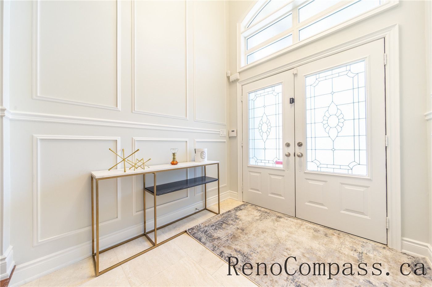 This Richmond Hill entire house interior renovation features a bright and elegant foyer with custom wall paneling, modern double entry doors, and refined decorative lighting. Clean lines, neutral tones, and high-end finishes create a welcoming and sophisticated entrance that reflects the quality craftsmanship of a professional Toronto renovation company. Designed to enhance natural light, functionality, and timeless style, this entryway sets the tone for the full home renovation.