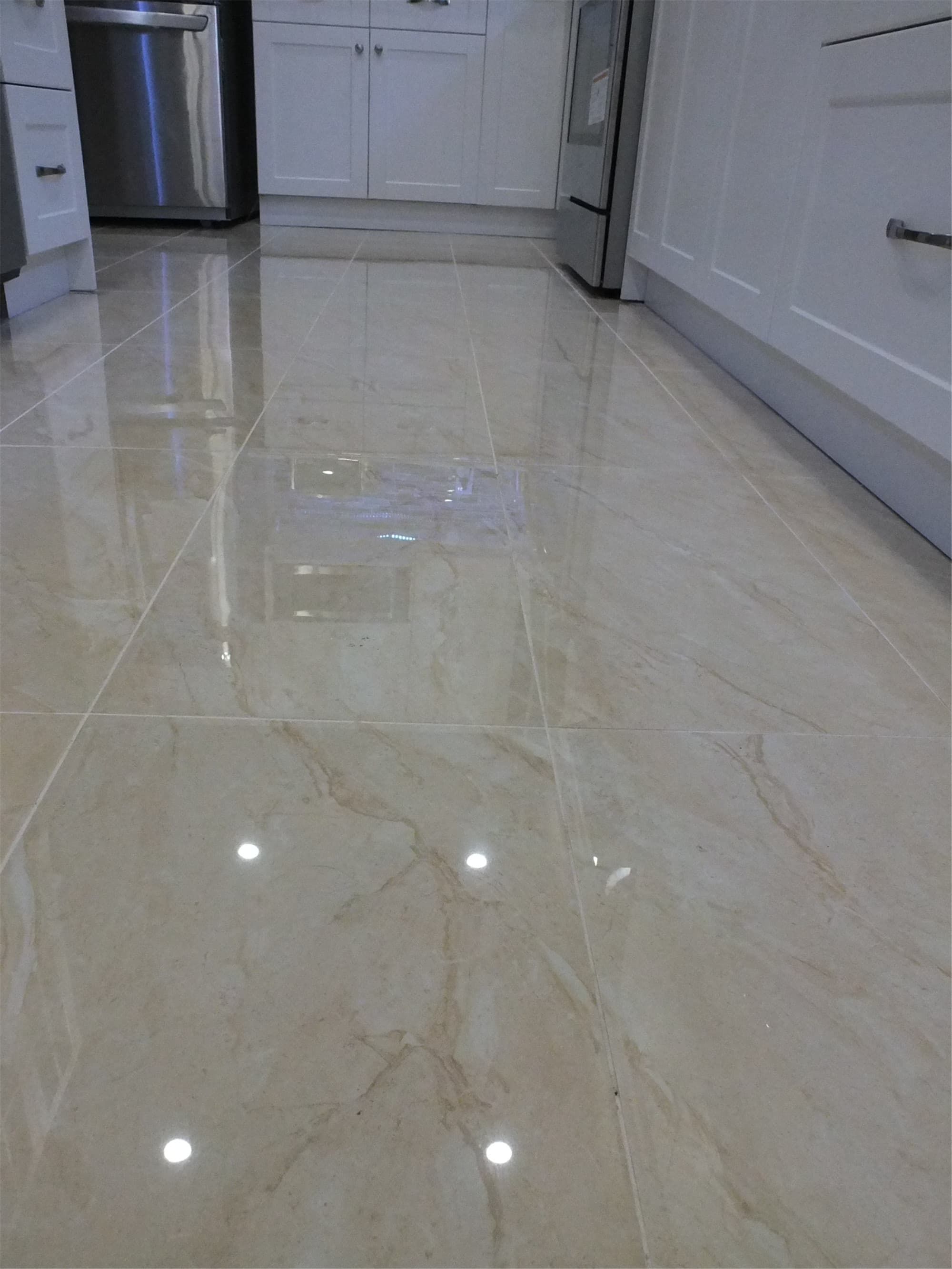This Vaughan kitchen renovation includes elegant polished porcelain floor tiles that enhance the brightness and modern feel of the space. The durable tile flooring complements the white cabinetry and contemporary kitchen design, providing both style and easy maintenance. Installed by a professional Toronto renovation company, the flooring adds long-lasting quality and visual depth to the renovated kitchen.