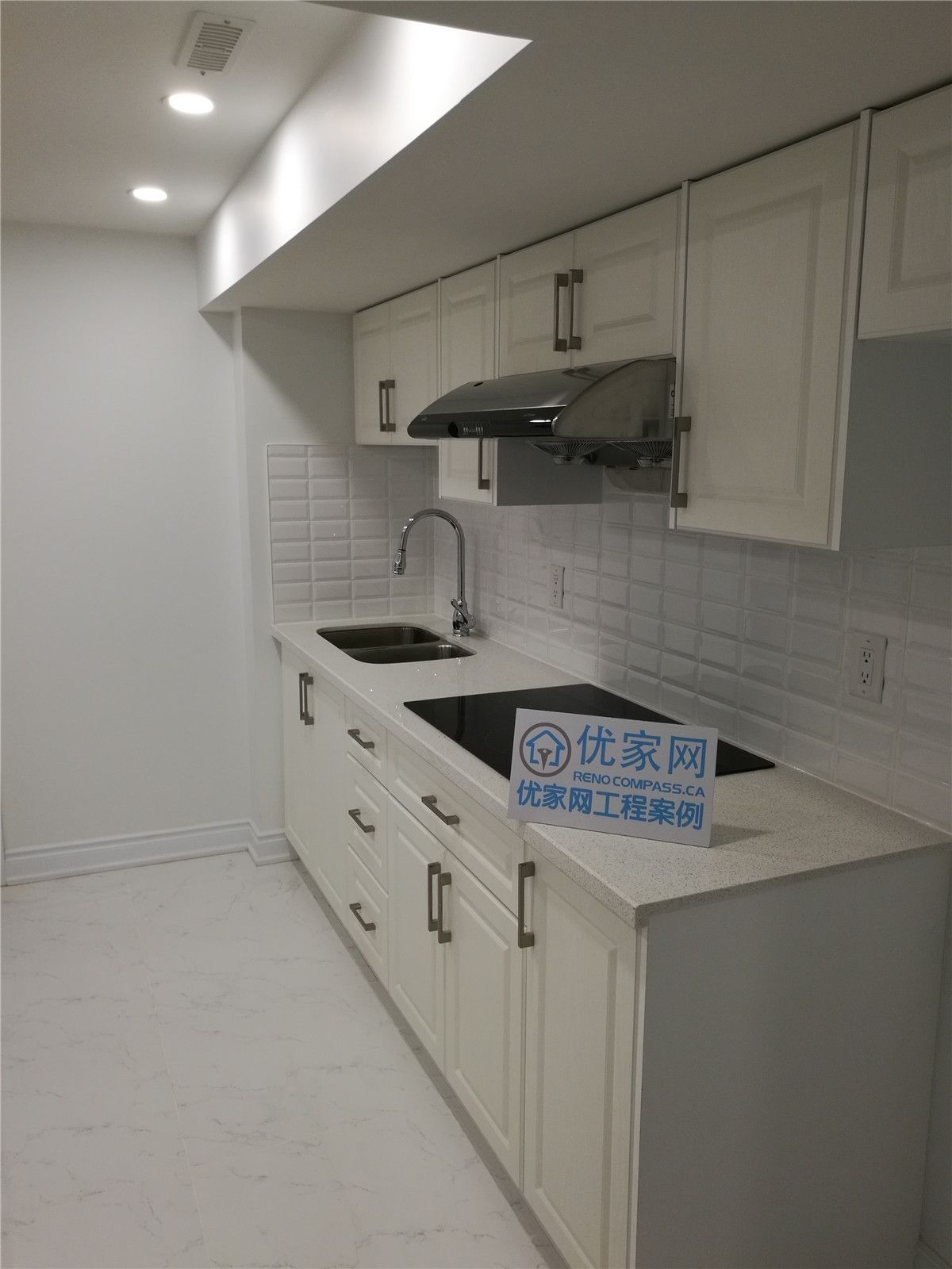 This image features a beautifully finished basement kitchen installed during a Vaughan basement renovation project. Designed for both functionality and modern style, the space includes custom white cabinetry, quartz countertops, a stainless steel sink, and a sleek range hood for a clean and contemporary look. The white subway tile backsplash and recessed lighting enhance brightness, making the basement kitchen feel open and inviting.

Careful space planning allows for efficient use of the narrow layout while maintaining comfortable workflow and storage capacity. Completed by a professional Toronto Renovation Company, this basement kitchen upgrade adds convenience, rental potential, and long-term value to the home through quality craftsmanship and refined finishing details.