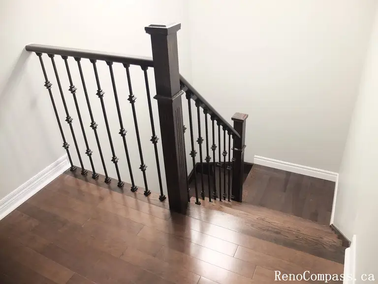 This Richmond Hill interior renovation showcases a modern staircase upgrade featuring dark hardwood flooring paired with custom black iron railings and solid wood posts. Completed by an experienced Toronto renovation company, the design enhances safety, durability, and visual elegance while creating a cohesive connection between floors. The refined railing details and warm wood tones add a sophisticated architectural element to the home’s interior.