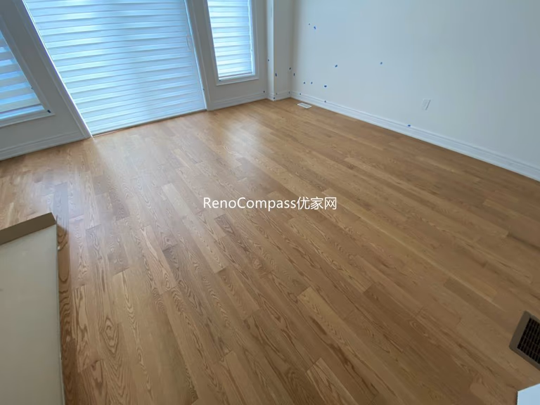 Spacious living area renovation featuring premium wood flooring and smooth neutral paint finish, creating a cozy and clean modern home by Reno Compass in Richmond Hill.