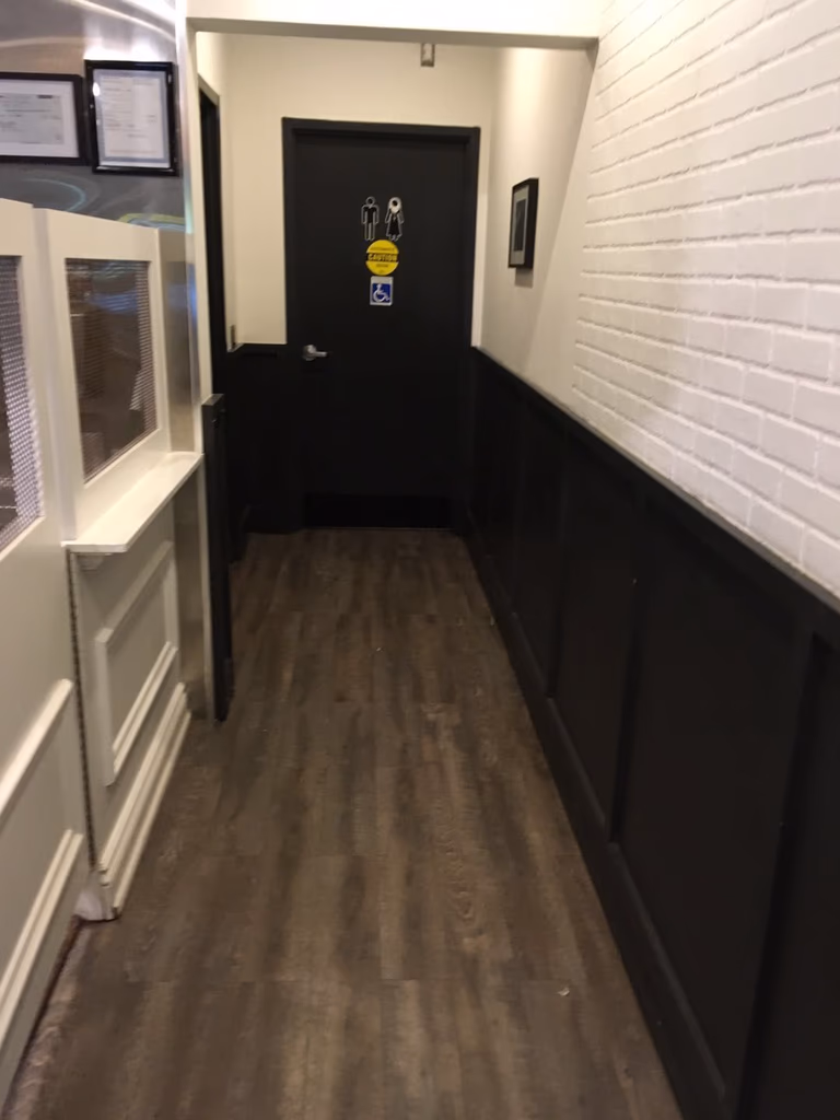 This Toronto spa renovation features a well-designed hallway leading to a commercial washroom, with durable flooring, decorative wall panels, and a clean, organized layout. The space ensures smooth customer flow while maintaining a modern and professional interior.