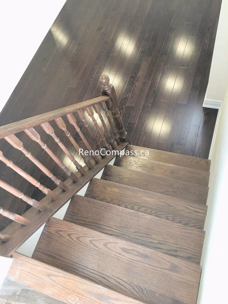 This Toronto basement renovation features newly installed hardwood stairs and matching engineered flooring, creating a clean and modern transition between levels. The upgraded staircase railing and rich wood tones enhance durability, safety, and overall home value. Completed by a professional Toronto renovation company, this project highlights quality craftsmanship and functional design for contemporary basement living spaces.