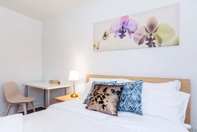 This Toronto interior renovation features a bright and cozy bedroom with minimalist styling. The space includes a comfortable bed setup, soft lighting, and a functional workspace corner, creating a relaxing and practical environment. Neutral tones and clean lines enhance the overall comfort, making it an ideal modern bedroom design for everyday living.