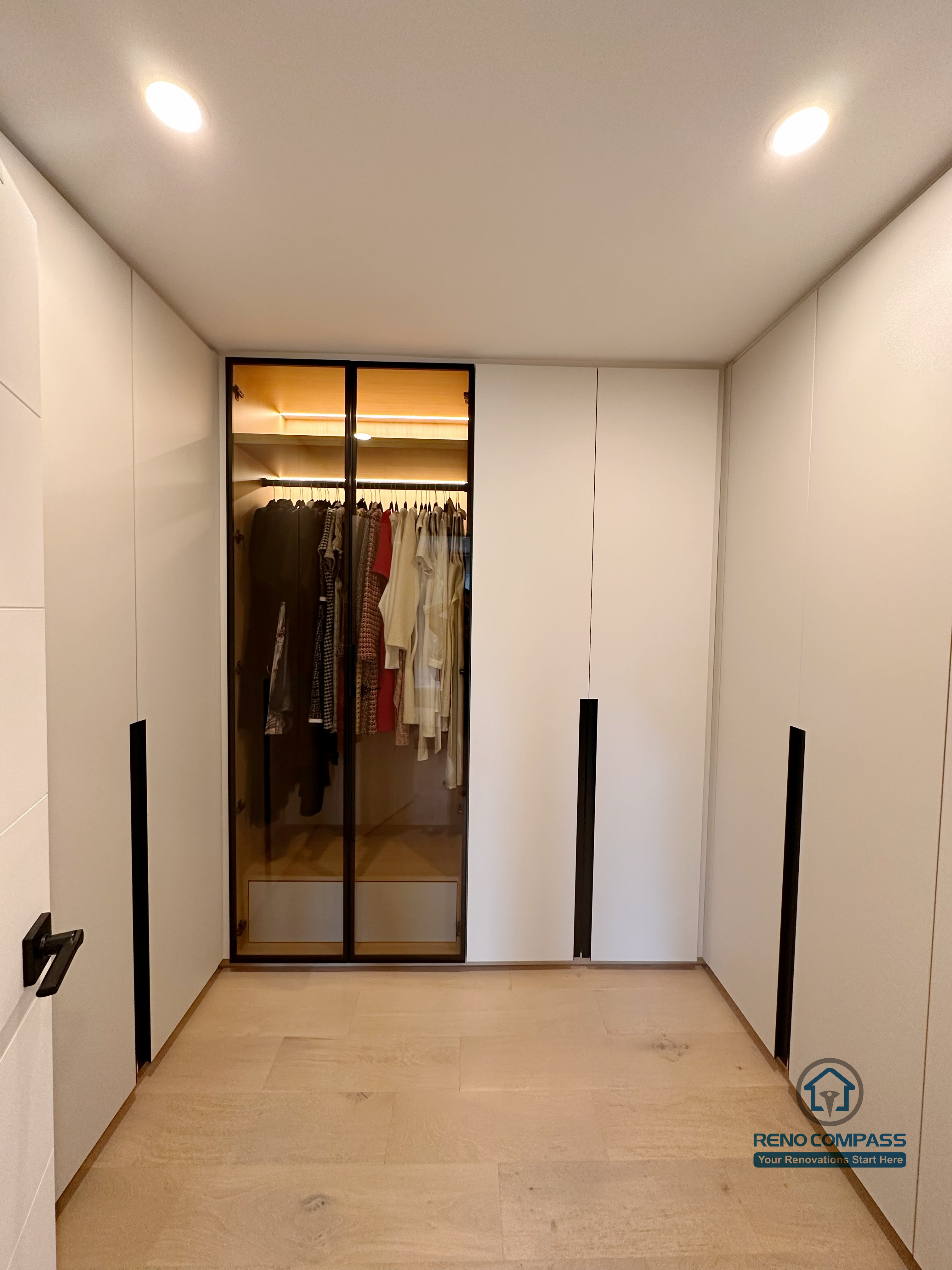 A custom walk-in closet renovation in Toronto featuring floor-to-ceiling glass wardrobe cabinetry with integrated LED lighting. This bespoke storage solution enhances organization and visibility while maintaining a sleek, modern look, completed by a professional Toronto renovation company.