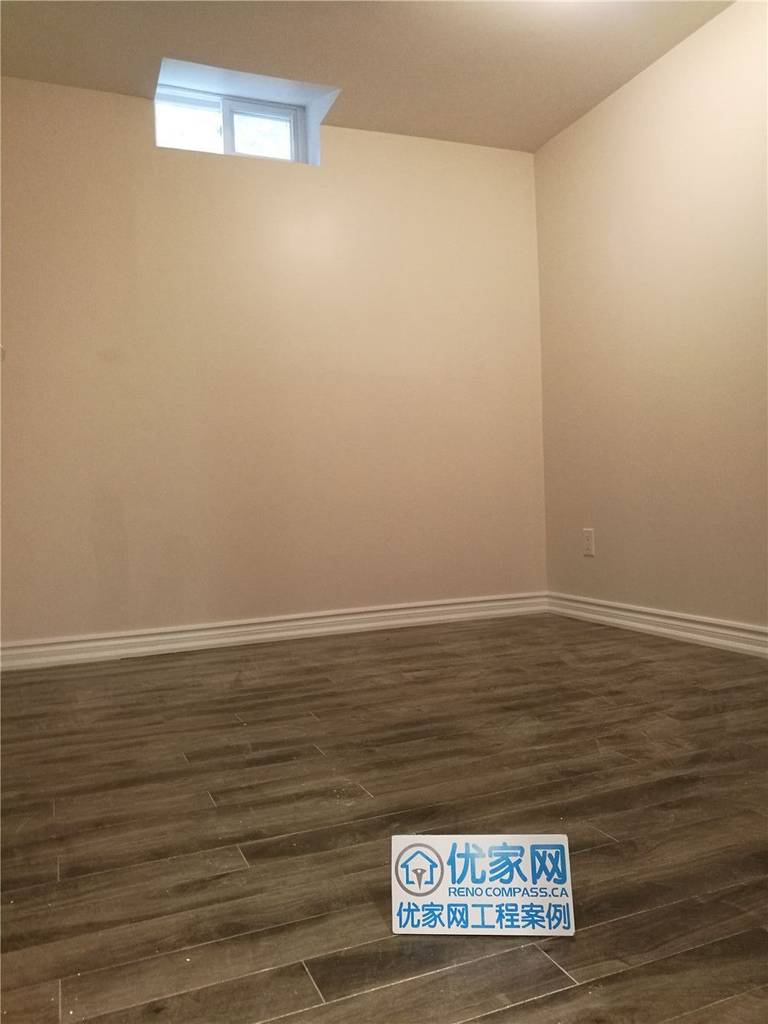 This image features a completed basement renovation project in Markham, showcasing a clean and functional finished basement space. Light-colored walls paired with durable wood-look flooring create a warm and modern atmosphere. A high-set window allows natural light to enter while maintaining privacy, making the space ideal for a home office, recreation room, or guest area. Completed by a professional Toronto Renovation Company, this basement renovation focuses on moisture-resistant materials, improved lighting, and practical layout planning to maximize everyday usability and long-term value.