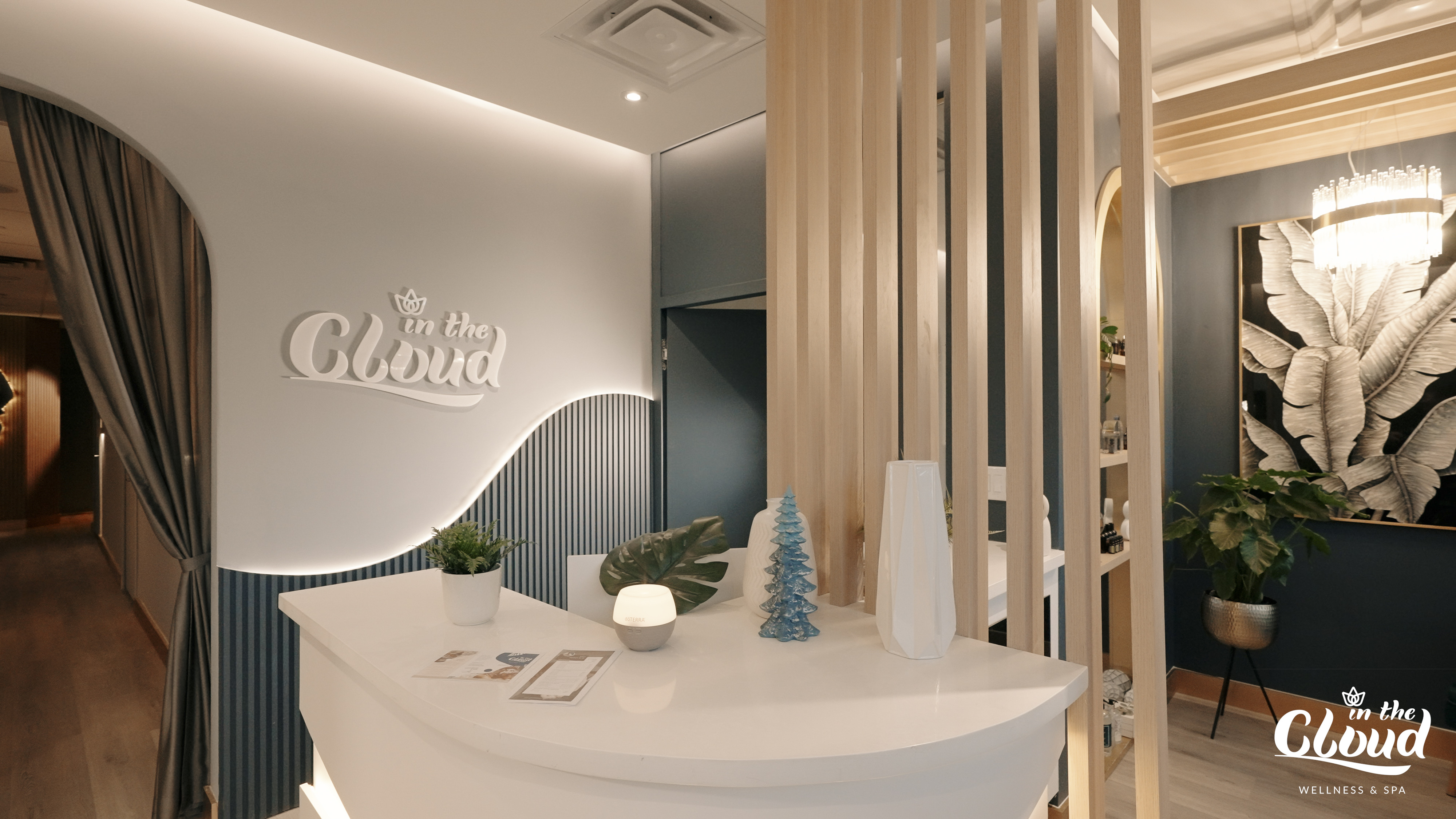 Custom reception desk detail completed as part of a North York beauty salon renovation. This image highlights curved millwork, soft ambient lighting, vertical wood slat accents, and integrated brand signage. The design enhances visual identity while maintaining smooth client flow and a calm, upscale atmosphere, delivered by a professional Toronto renovation company.