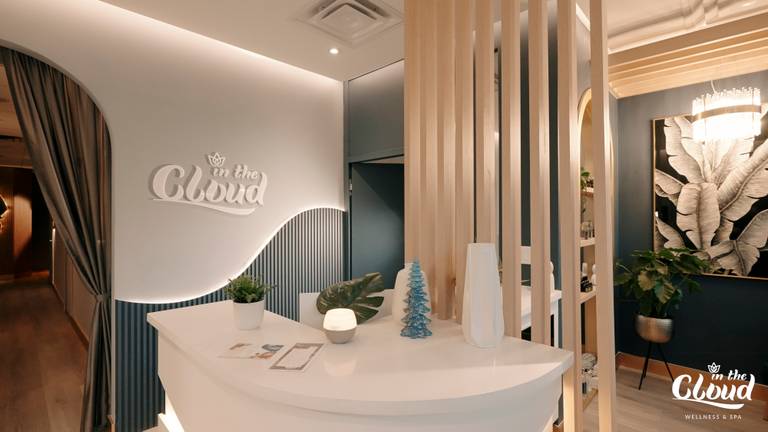 Custom reception desk detail completed as part of a North York beauty salon renovation. This image highlights curved millwork, soft ambient lighting, vertical wood slat accents, and integrated brand signage. The design enhances visual identity while maintaining smooth client flow and a calm, upscale atmosphere, delivered by a professional Toronto renovation company.