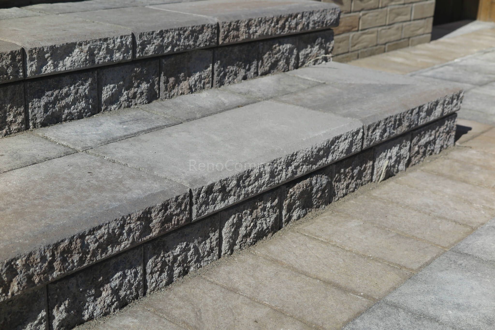 Close-up detail of professionally installed interlocking stone steps and patio in this Aurora landscaping project. The textured stone finish and clean edge alignment create a durable and elegant outdoor transition between patio and home entrance. Completed by Reno Compass Inc., a trusted Toronto renovation and landscaping company serving Aurora and the GTA.