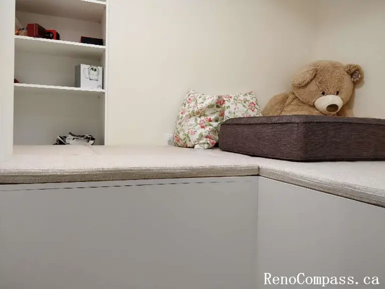 A high-quality custom mudroom renovation in Markham featuring white shaker-style lower cabinets, a built-in seating bench, open cubby shelving, and an integrated garment hanging rod for maximum organization.