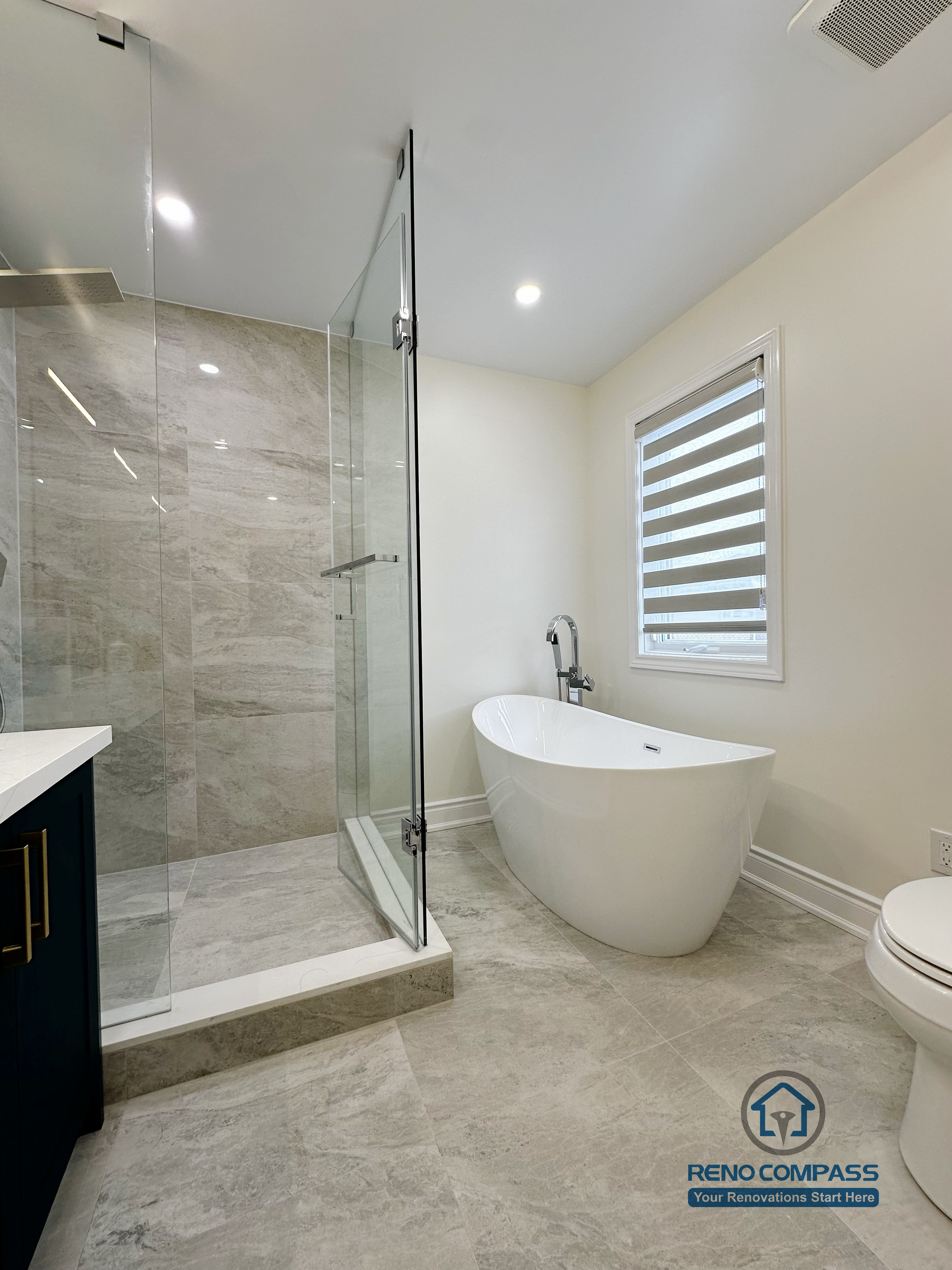 Master bathroom renovation in Markham featuring a freestanding soaking tub, frameless glass shower, and large-format tile flooring. The layout emphasizes openness, natural light, and a calm spa-inspired atmosphere with modern finishes.