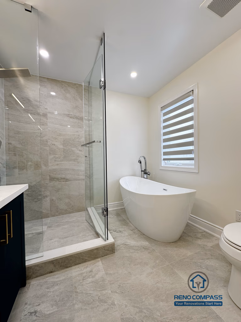 Master bathroom renovation in Markham featuring a freestanding soaking tub, frameless glass shower, and large-format tile flooring. The layout emphasizes openness, natural light, and a calm spa-inspired atmosphere with modern finishes.