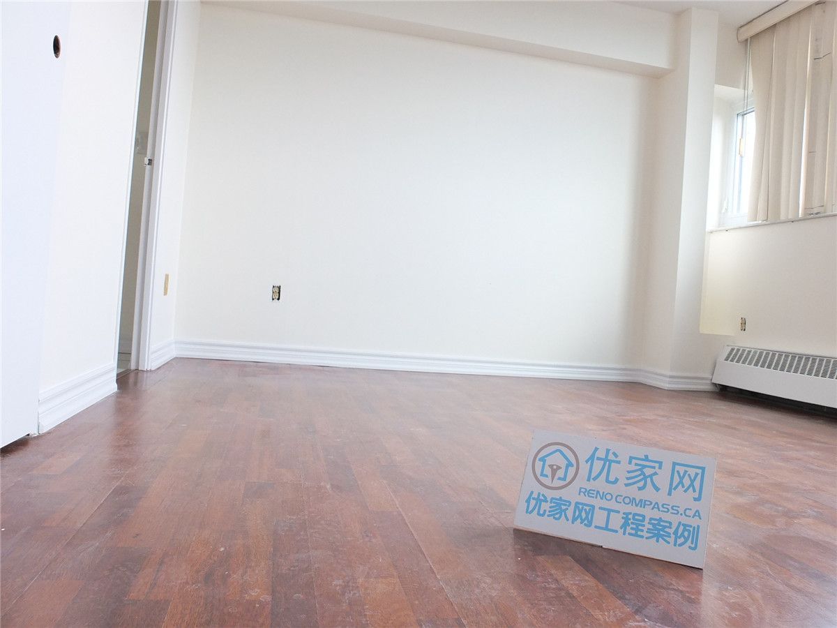 A bright and refreshed condo interior in Scarborough featuring newly installed flooring and clean white walls. This open living space benefits from large windows that enhance natural light, creating a warm and comfortable atmosphere. The renovation improves overall functionality and visual appeal, showcasing professional interior renovation work by a Toronto renovation company.