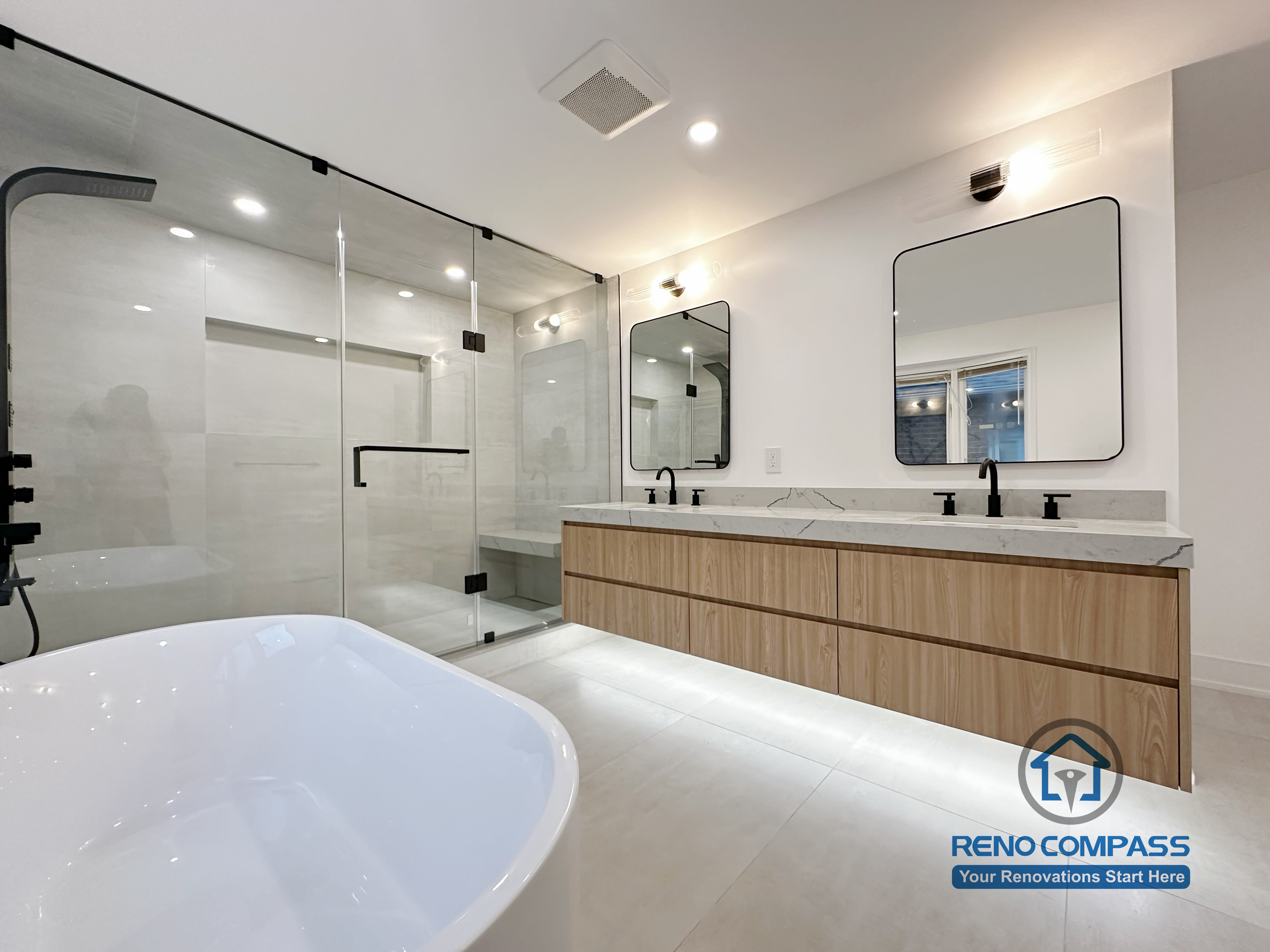 Full Oakville bathroom renovation showcasing a freestanding bathtub, frameless glass shower, and custom double vanity with quartz countertop, completed by a professional Toronto renovation company.