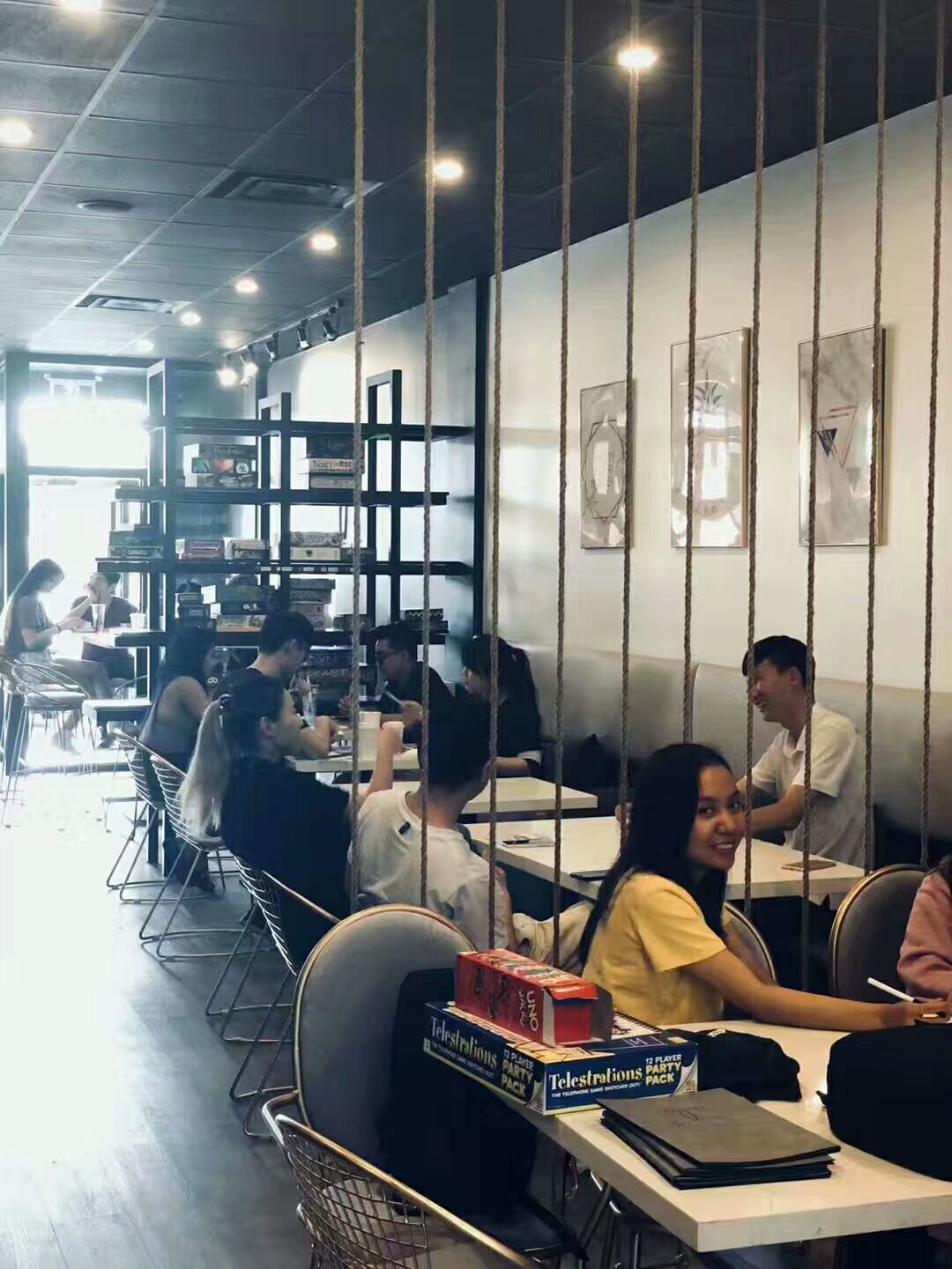 This image shows the seating area of a renovated bubble tea shop in Scarborough. The interior design features modern dining tables, comfortable seating, decorative rope dividers, and warm ceiling lighting that create a welcoming environment for customers. The open layout allows efficient use of space while maintaining a stylish and relaxed atmosphere. This commercial renovation project demonstrates thoughtful space planning and interior design tailored for a busy bubble tea shop.