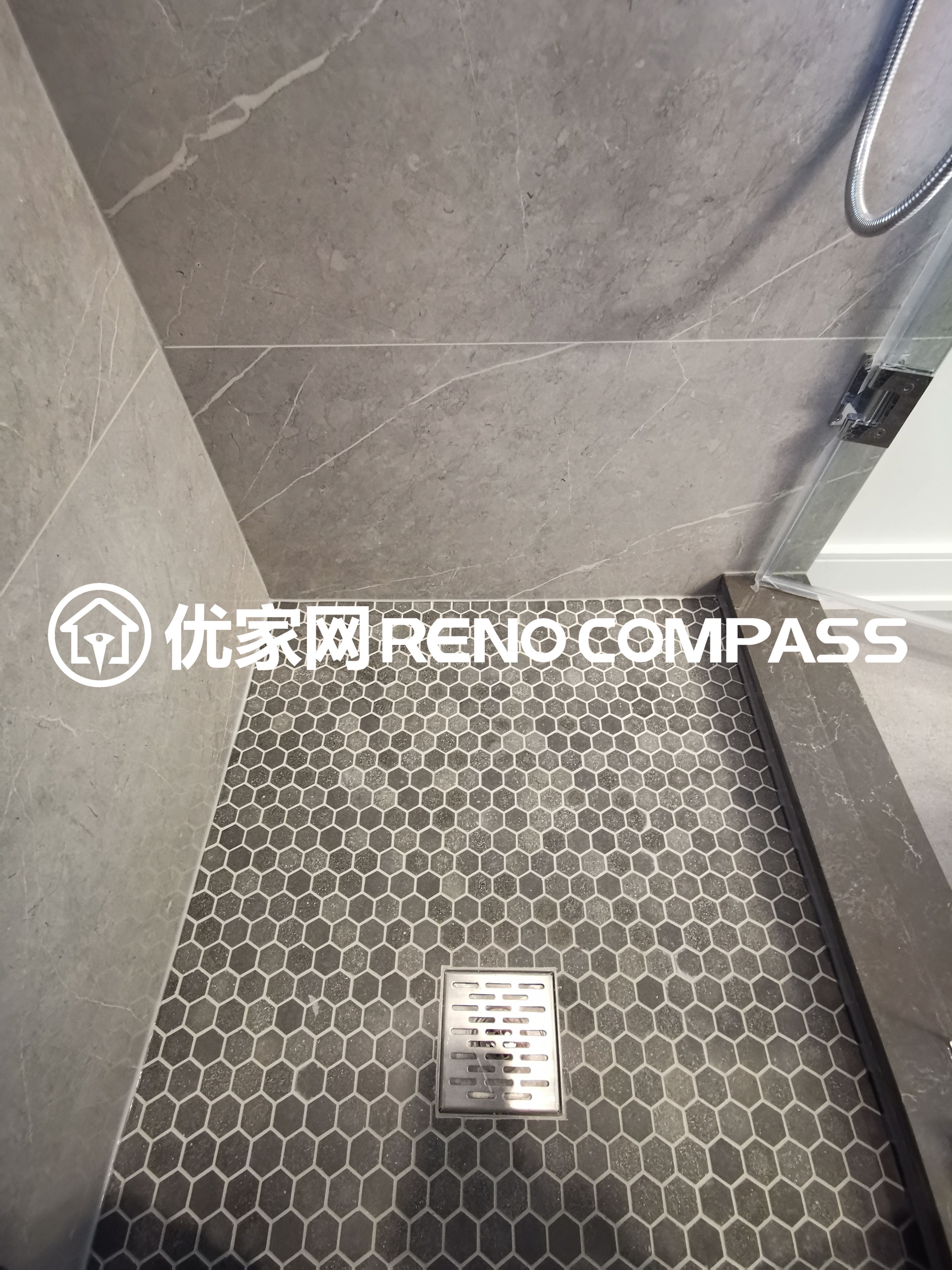 This image highlights the shower floor detail completed as part of a North York interior renovation project. The walk-in shower features mosaic floor tiles that enhance slip resistance while adding subtle texture to the space. A centrally positioned drain ensures efficient water flow and proper slope control, reflecting precise installation and attention to construction standards. The combination of durable materials and clean tile alignment demonstrates quality craftsmanship and thoughtful bathroom design for modern Toronto homes.