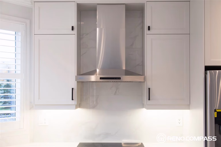 This Markham kitchen renovation highlights custom white shaker cabinets paired with a sleek stainless steel range hood and marble-look backsplash. The clean lines, modern finishes, and built-in cabinetry create a bright, functional, and elegant cooking space designed for both style and everyday use.