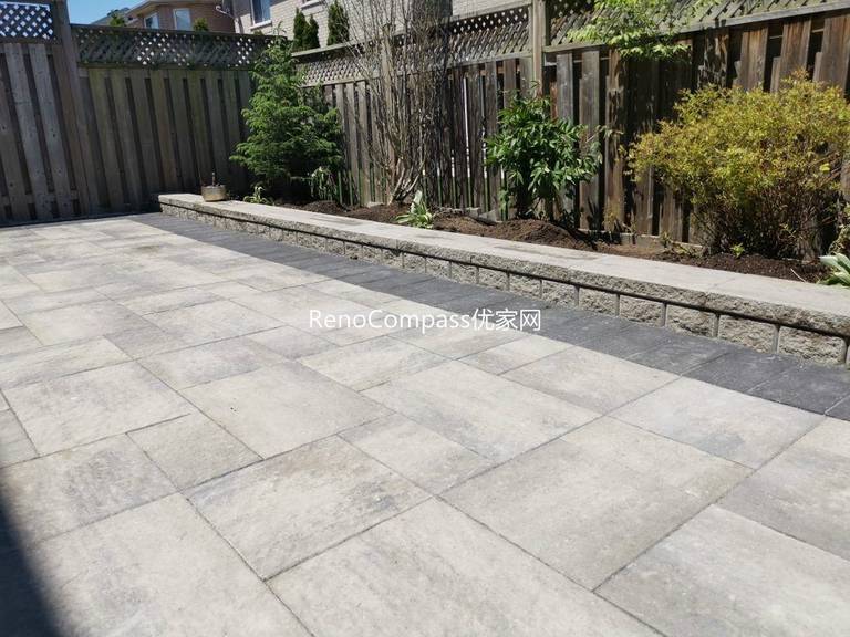This Mississauga backyard renovation showcases a professionally installed interlocking stone patio with clean modern lines and a raised garden retaining wall. Large-format pavers create a durable and elegant outdoor flooring solution, while the stone border and planting area add depth and structure to the landscape. Completed by an experienced Toronto renovation and landscaping team, this project enhances outdoor usability, drainage, and long-term property value with low-maintenance, high-quality materials.
