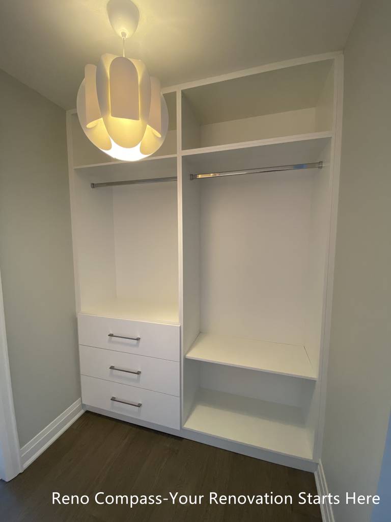 Custom walk-in closet featured in an Oakville interior renovation, showcasing built-in shelving, hanging rods, and integrated drawer storage for optimal organization. The clean white cabinetry and functional layout provide a modern storage solution designed and completed by a professional Toronto renovation company.