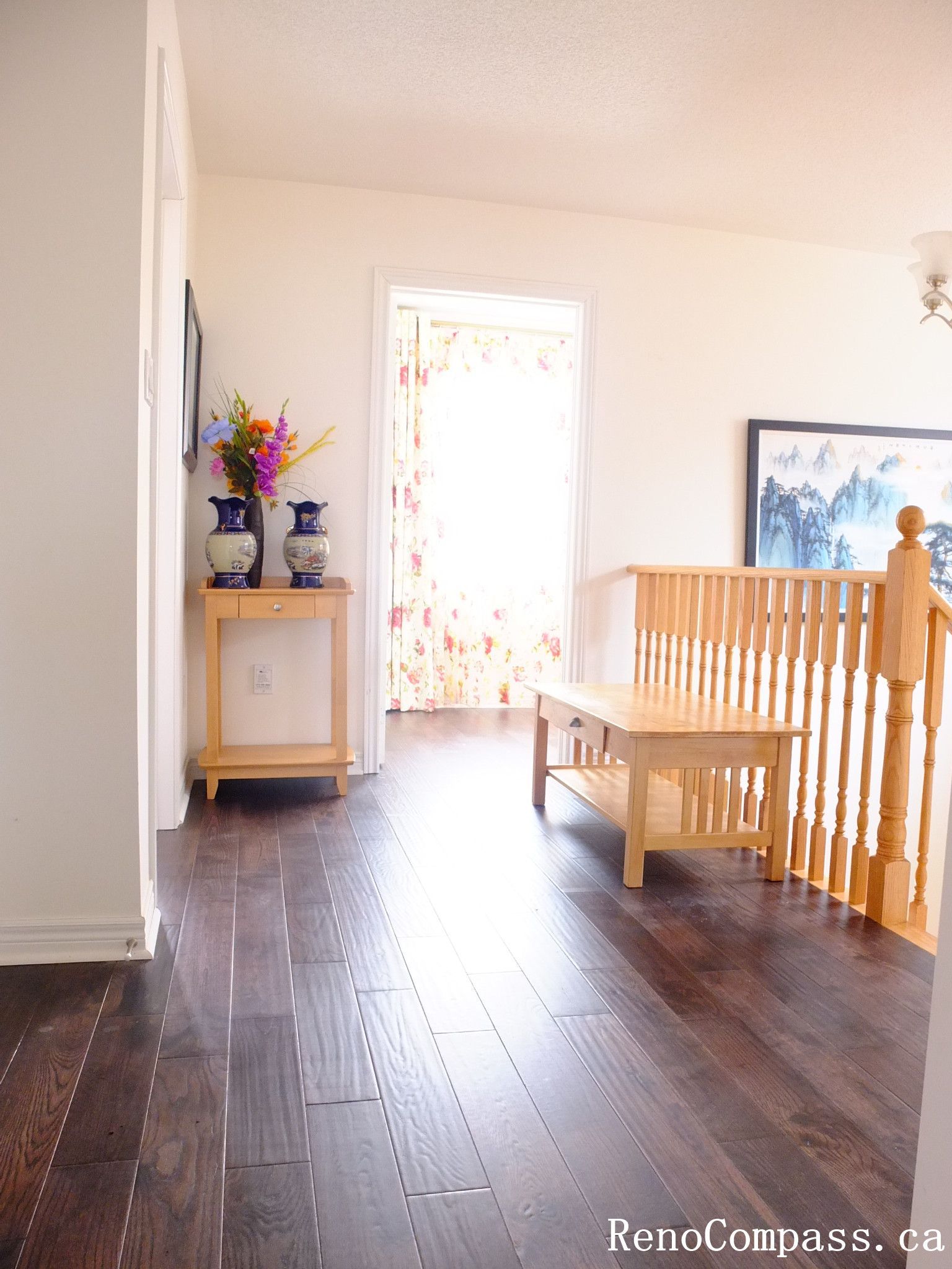 Toronto home hardwood flooring installation featuring deep-toned wood floors throughout the hallway and upper level. This professional flooring renovation enhances brightness, durability, and visual continuity, completed by Reno Compass for a clean and modern interior upgrade.