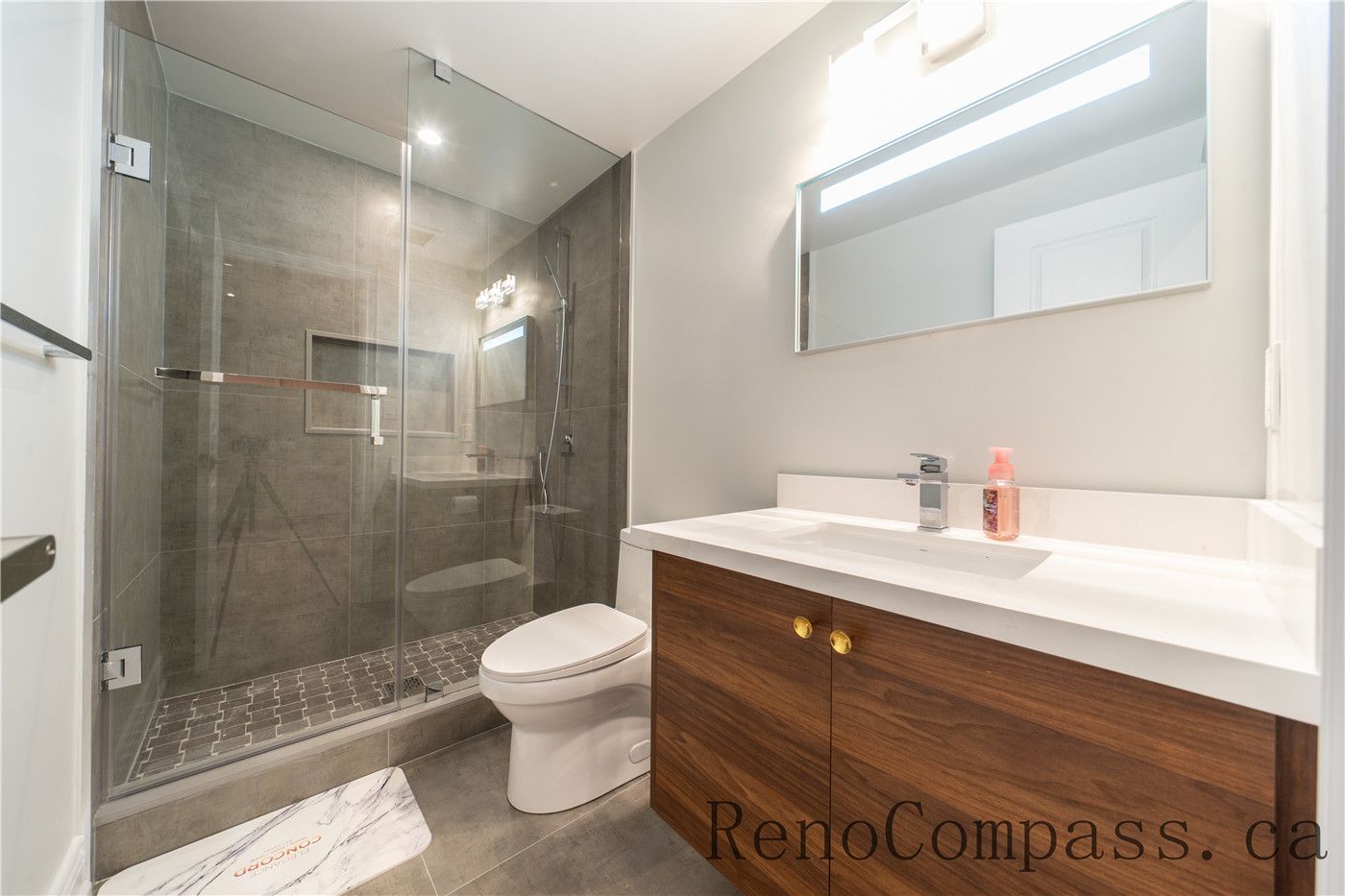 This Richmond Hill entire house interior renovation features a modern bathroom with a frameless glass shower, custom wood vanity, and sleek contemporary fixtures. Neutral tile finishes, integrated lighting, and a clean layout create a bright and comfortable space for daily use. Completed by an experienced Toronto renovation company, this bathroom renovation combines durability, functionality, and modern design to enhance overall home value and comfort.