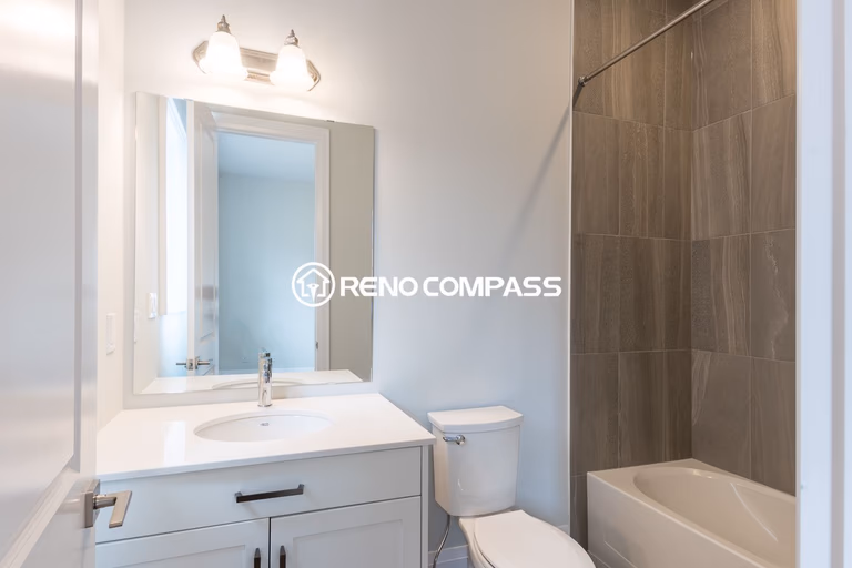 Clean and modern bathroom renovation in Newmarket featuring a vanity cabinet with quartz countertop, bathtub and shower combination, and contemporary wall tile design. Completed by a professional Toronto renovation company, this bathroom upgrade improves both comfort and functionality for daily living.