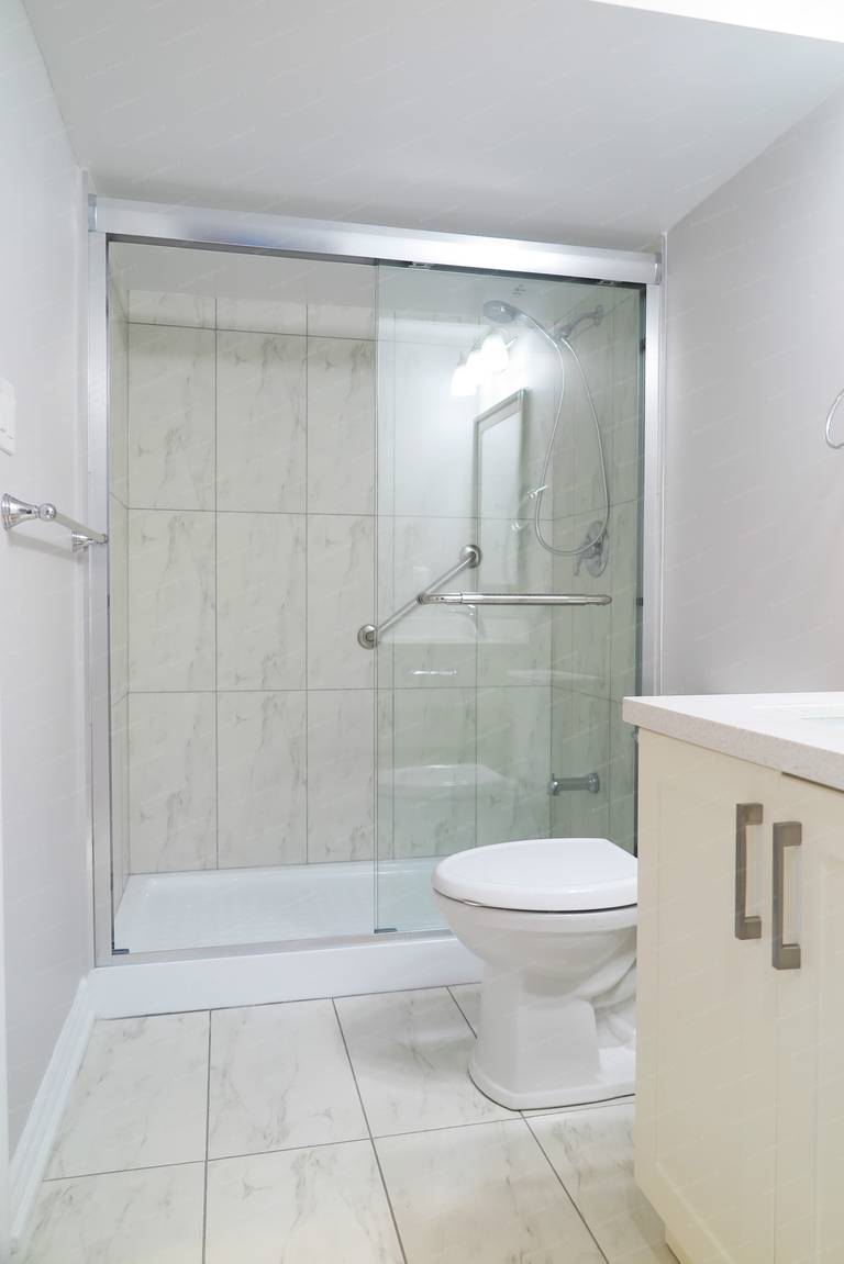 This Richmond Hill basement bathroom renovation features a walk-in glass shower, light-toned tile finishes, and a clean, functional layout designed for everyday comfort.