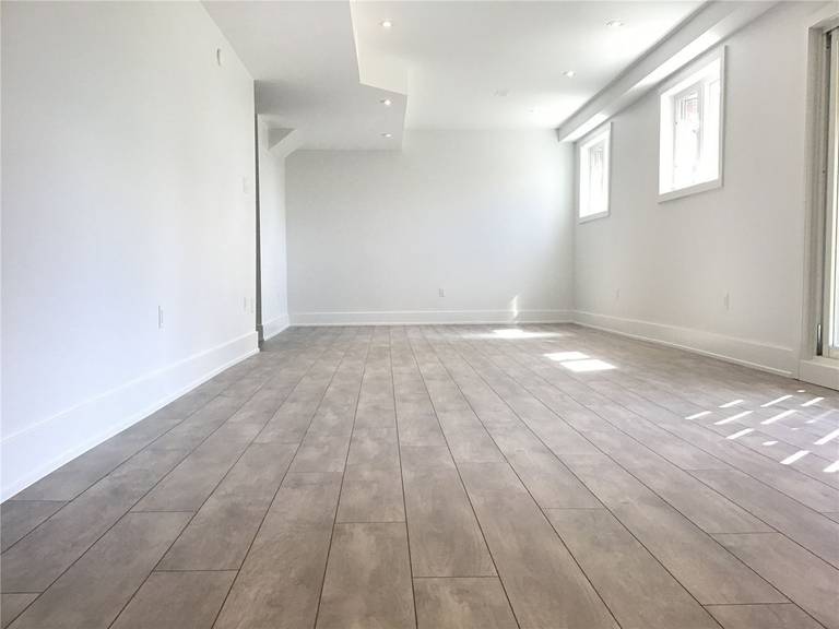 This Markham full home renovation features a spacious and fully finished basement with modern vinyl plank flooring, recessed lighting, and large windows for natural light. The open layout provides flexible space for entertainment, home office, or additional living areas. Completed by a trusted Toronto Renovation Company, this basement design enhances both usability and property value.