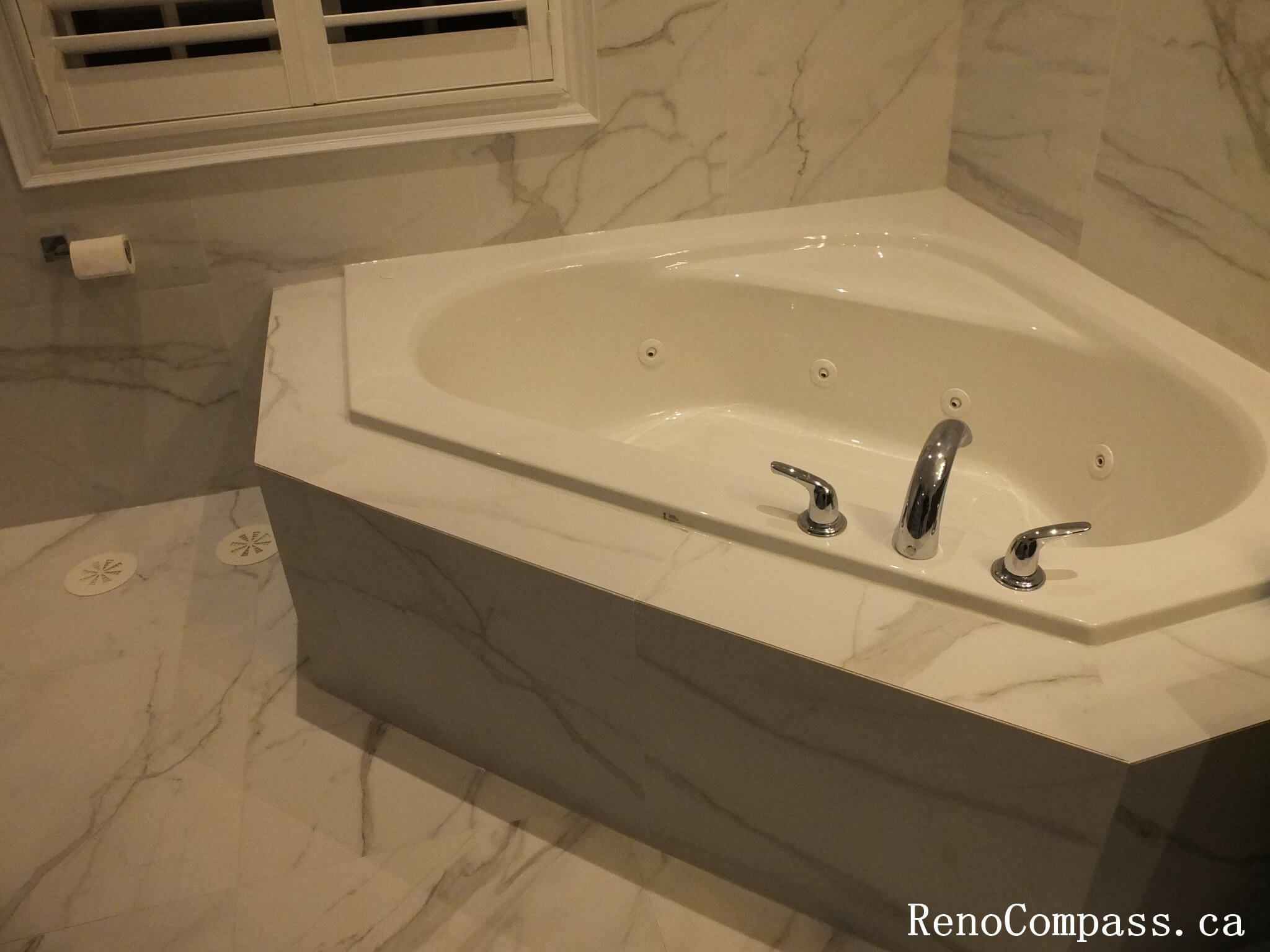 Transform your bathroom into a private spa. This Unionville renovation features a premium corner whirlpool tub with seamless marble tile integration, perfect for relaxation and modern style.