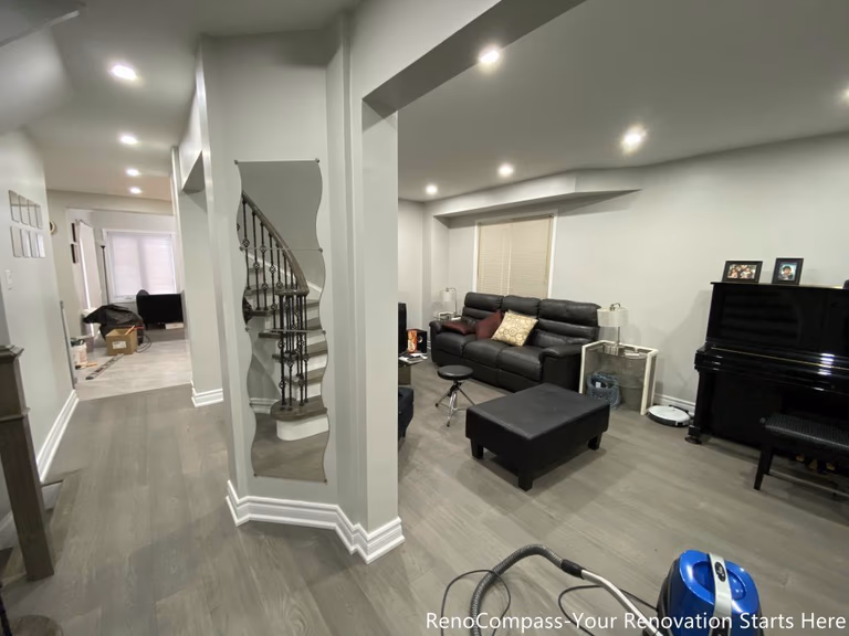 This Mississauga interior renovation features a modern open-concept living space with upgraded flooring, smooth ceilings, and recessed pot lights that create a bright and welcoming atmosphere. The redesigned layout highlights a custom staircase feature wall, contemporary trim work, and a seamless transition between living and dining areas. Completed by a professional Toronto renovation company, this renovation focuses on enhancing space flow, lighting quality, and overall home comfort while adding long-term value and a clean modern aesthetic.