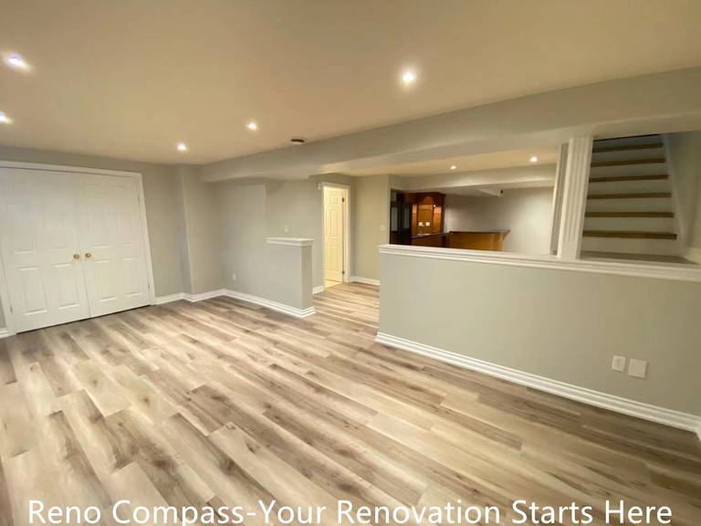 This Oakville interior renovation features a newly finished open-concept basement designed to maximize space, brightness, and everyday usability. Wide-plank vinyl flooring provides durability and a natural wood appearance, while recessed ceiling lights create even illumination throughout the area. Half-height partition walls subtly define zones without blocking sightlines, maintaining an open and connected layout. Neutral wall tones enhance the sense of openness, making the basement suitable for a family room, recreation space, or home office. This project demonstrates a practical and modern basement transformation completed by an experienced Toronto renovation company.