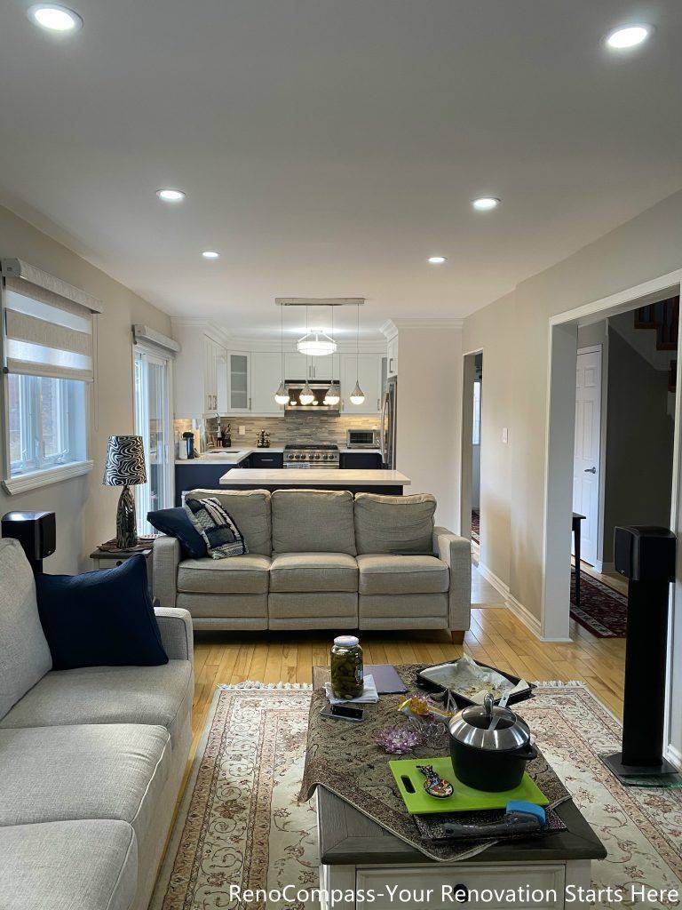 A bright open-concept living area completed as part of a Newmarket interior renovation, featuring neutral tones, recessed lighting, hardwood flooring, and a seamless connection between the living, dining, and kitchen spaces by a Toronto renovation company.