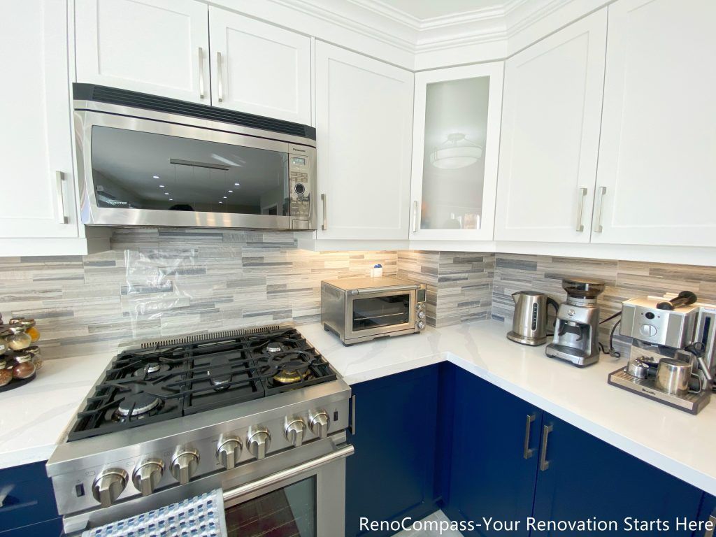 A detailed view of the kitchen cooking area from a Newmarket interior renovation, featuring a gas range, built-in microwave, quartz countertops, and custom cabinetry designed for everyday functionality by a Toronto renovation company.