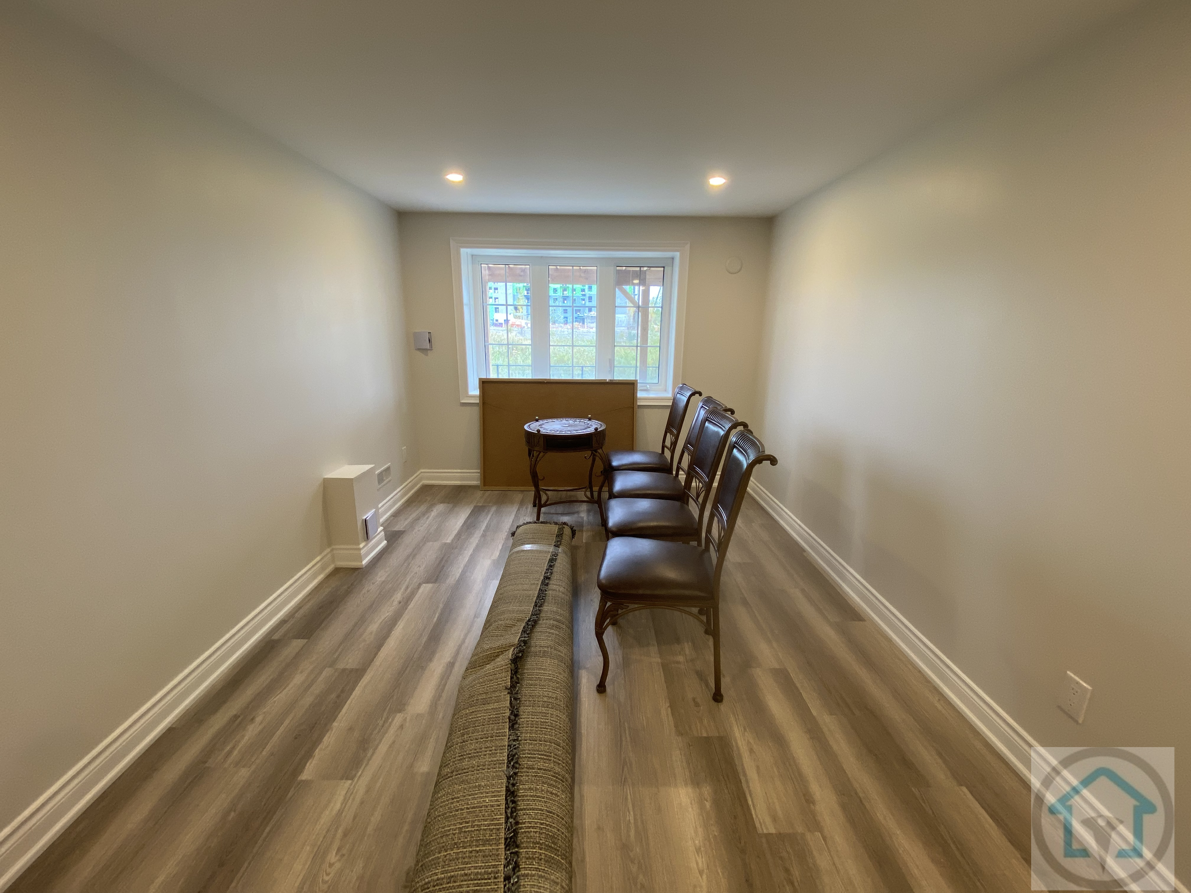 This Newmarket basement renovation includes a finished multi-purpose room with upgraded flooring, recessed ceiling lights, and a centered window that enhances natural light. The clean layout and balanced proportions make the space suitable for a home office, sitting area, or flexible secondary living zone within the basement.